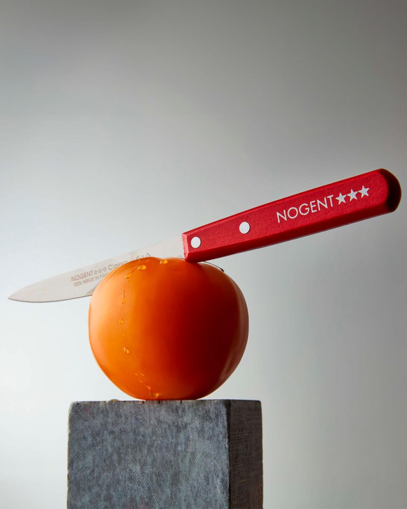 Nogent serrated knife about to cut a tomato